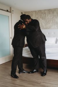 best man and groom embrace at Baton Renaissance Hotel wedding