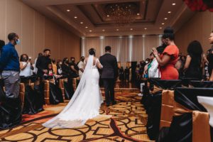 pull back view of bride walking down isle at Baton Renaissance Hotel wedding