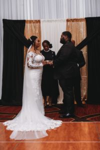 bride and groom holding hands in ceremony at Baton Renaissance Hotel wedding